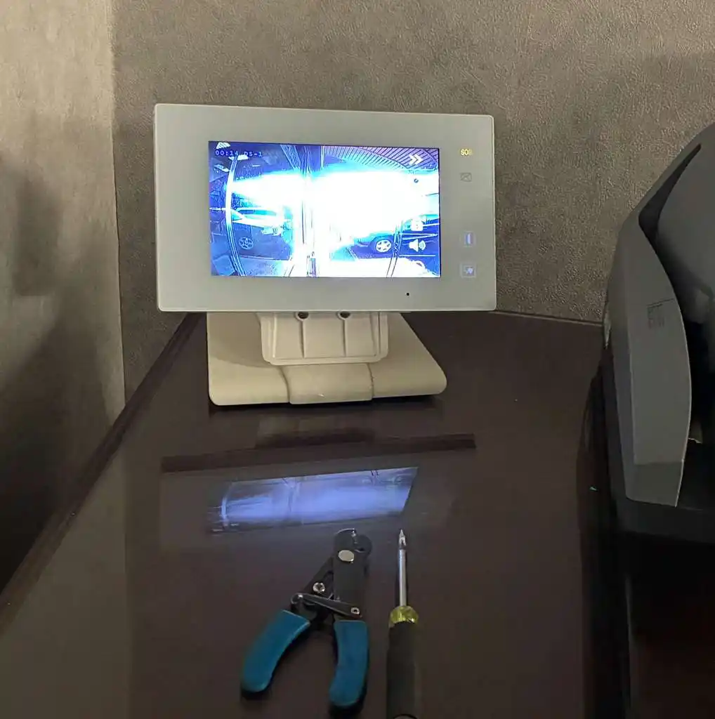 White video intercom monitor displaying a live camera feed during installation