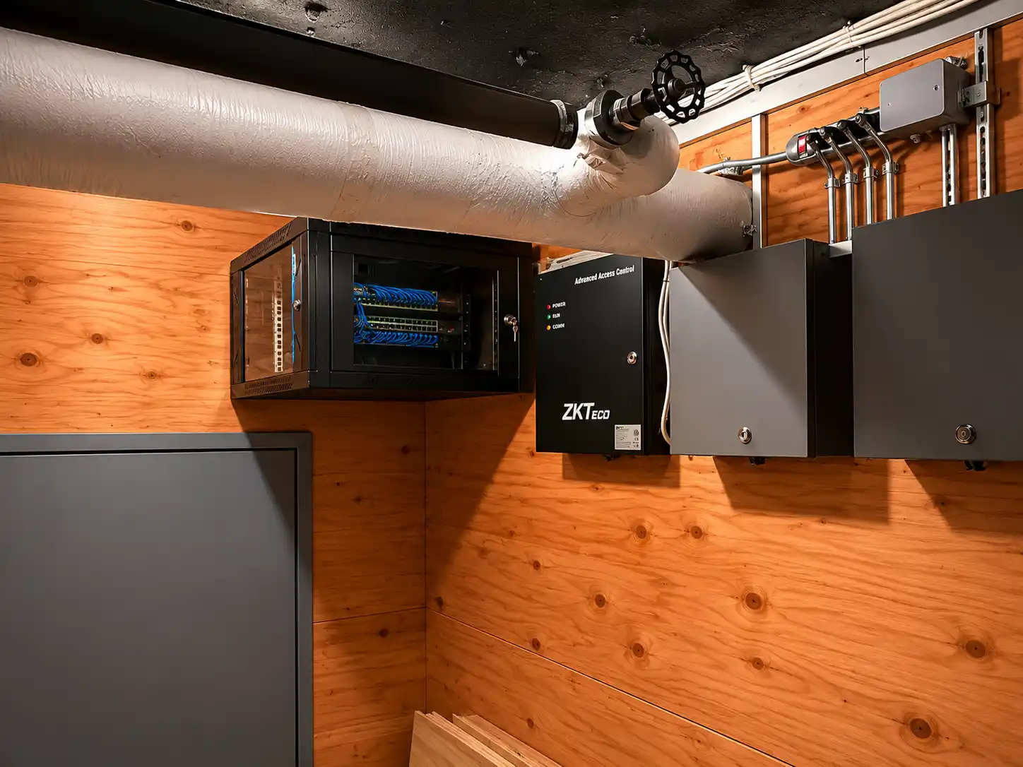 Access control cabinet and network rack mounted on a plywood backboard