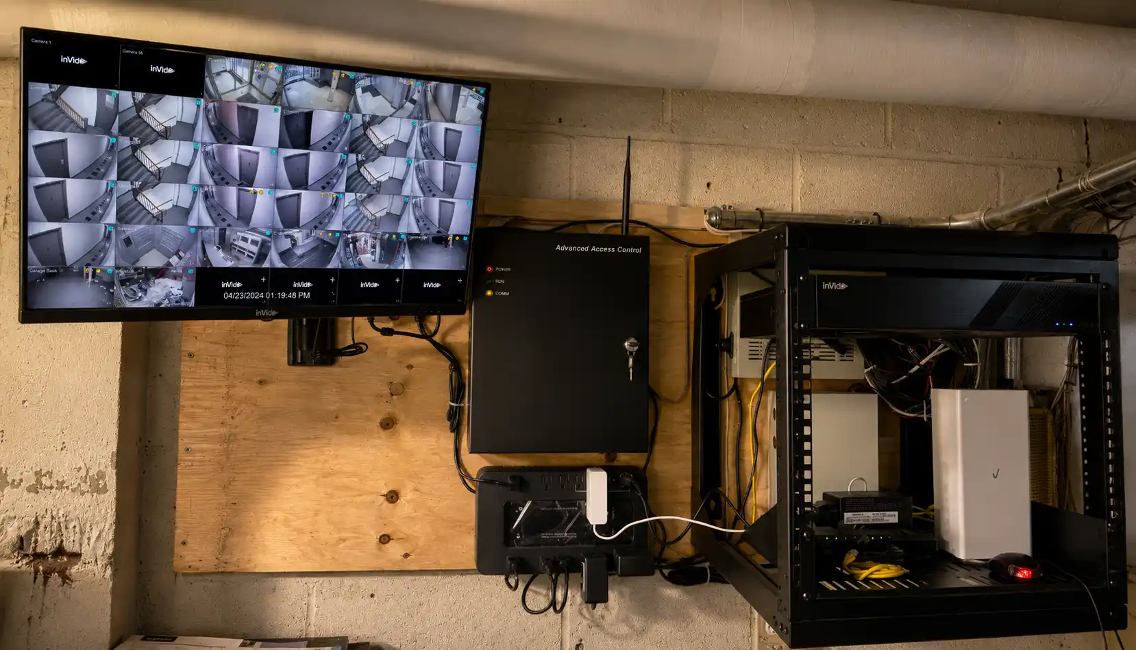 Security monitor wall and equipment rack installed in a building utility room